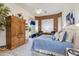 A bright main bedroom features large bed, light blue accents, ceiling fan, sitting area, and closet at 4511 E Kirkland Rd, Phoenix, AZ 85050