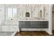 Elegant bathroom featuring a marble tiled shower and dual vanity with modern fixtures at 4563 E Libby St, Phoenix, AZ 85032