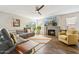 Comfortable living room featuring fireplace, mounted tv, wood floors, and ample natural light at 4563 E Libby St, Phoenix, AZ 85032