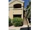 Exterior view of a two story tan home with a staircase, beautiful shrubbery, and a small balcony at 5335 E Shea Blvd Blvd # 2095, Scottsdale, AZ 85254