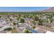 Sprawling aerial view of a lush community featuring mature trees, homes with pools, and distant mountain views at 6255 E Rose Circle Dr, Scottsdale, AZ 85251