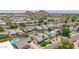 Expansive aerial view showcasing a neighborhood with pools and desert landscaping set against a backdrop of rugged mountain peaks at 6255 E Rose Circle Dr, Scottsdale, AZ 85251
