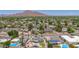 Aerial view of a neighborhood featuring mature trees and some homes with pools against a backdrop of a mountain range at 6255 E Rose Circle Dr, Scottsdale, AZ 85251