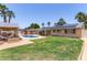 Expansive backyard featuring a pool, patio, and verdant lawn offers endless possibilities for outdoor living at 6255 E Rose Circle Dr, Scottsdale, AZ 85251