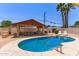 Backyard oasis featuring a sparkling pool, covered patio, and outdoor kitchen for ultimate enjoyment at 6255 E Rose Circle Dr, Scottsdale, AZ 85251