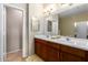 Bathroom with double sinks, wood cabinets, large mirror, decorative lighting, and ceramic tile flooring at 6745 N 93Rd Ave # 1129, Glendale, AZ 85305