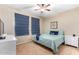 Bedroom with a ceiling fan, large window with blue shades, and queen-sized bed with decorative pillows at 6745 N 93Rd Ave # 1129, Glendale, AZ 85305