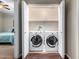 Laundry closet with wood floors, bi-fold doors, and a full-size washer and dryer set at 6745 N 93Rd Ave # 1129, Glendale, AZ 85305