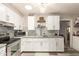 Well-lit kitchen with stainless steel appliances, white cabinetry, gray countertops, and a subway tile backsplash at 6802 S 47Th St, Phoenix, AZ 85042