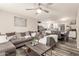 Open concept living room featuring a comfortable sectional sofa, ceiling fan, and views into the kitchen at 6802 S 47Th St, Phoenix, AZ 85042