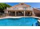 Beautiful backyard with a pool, covered patio, and wrought iron fencing, perfect for outdoor entertainment at 735 W Kelton Ln, Phoenix, AZ 85023