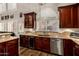 Gourmet kitchen featuring cherry cabinets, granite countertops, and stainless steel appliances at 735 W Kelton Ln, Phoenix, AZ 85023