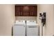 Functional laundry room with modern washer, dryer, dark cabinets and vacuum for easy chores at 735 W Kelton Ln, Phoenix, AZ 85023