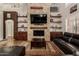 Inviting living room with a stone fireplace, built-in shelves and a cozy seating area at 735 W Kelton Ln, Phoenix, AZ 85023