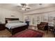 Spacious main bedroom with ceiling fan, wooden floors, red rug, and french door access to patio at 735 W Kelton Ln, Phoenix, AZ 85023