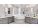 A spa-like bathroom features dual vanities, soaking tub, and elegant lighting fixtures at 757 W Carob Way, Chandler, AZ 85248
