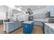Bright kitchen features blue cabinetry, a central island, stainless steel appliances, and modern lighting at 757 W Carob Way, Chandler, AZ 85248