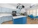 Bright kitchen with blue cabinetry, a central island, stainless steel appliances, and modern lighting fixtures at 757 W Carob Way, Chandler, AZ 85248