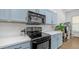 Close-up of kitchen showcasing black appliances, light countertops, and blue cabinets with modern hardware at 757 W Carob Way, Chandler, AZ 85248