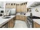 Modern kitchen featuring stainless steel appliances, white countertops, and custom light wood cabinetry at 7774 E San Fernando Dr, Scottsdale, AZ 85255