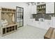 Spacious laundry room with gray tile backsplash, butcher block countertops, custom shelving, and a hall tree at 7774 E San Fernando Dr, Scottsdale, AZ 85255