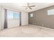 Cozy bedroom with carpet, ceiling fan and plenty of light from the large windows at 778 W Lowell Dr, San Tan Valley, AZ 85140