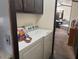 This laundry room has white appliances and dark wood cabinets at 9302 E Broadway Rd # 129, Mesa, AZ 85208