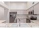 Well-lit kitchen featuring stainless steel appliances, white cabinets, and marble countertops at 1021 S Greenfield Rd # 1211, Mesa, AZ 85206