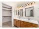 Bathroom with dual sinks, ample lighting, and a view into the walk-in closet at 11338 E Contessa St, Mesa, AZ 85207