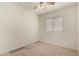 Cozy bedroom featuring soft carpeting, a ceiling fan, and a bright window at 11338 E Contessa St, Mesa, AZ 85207