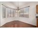 Bright dining area features wood floors, a charming chandelier, and large windows at 11338 E Contessa St, Mesa, AZ 85207