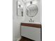 Modern bathroom vanity with stylish round mirror, updated lighting, and sleek faucet at 122 S Hardy Dr # 62, Tempe, AZ 85281