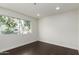 A simple bedroom with dark floors, white trim, and a window at 122 S Hardy Dr # 62, Tempe, AZ 85281