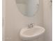 Simple half bathroom featuring a pedestal sink and round mirror at 1367 S Country Club S Dr # 1125, Mesa, AZ 85210