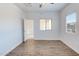 Bright bedroom with two windows, ceiling fan, wood floors, and view into the hall at 1367 S Country Club S Dr # 1125, Mesa, AZ 85210