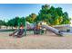 Community playground with slides and climbing structures on a soft mulch surface for safe play at 1367 S Country Club S Dr # 1125, Mesa, AZ 85210