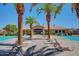 Community pool with palm trees, lounge chairs, and a clubhouse in the background at 1367 S Country Club S Dr # 1125, Mesa, AZ 85210