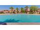 Community pool with palm trees, lounge chairs, water features, and residential buildings in the background at 1367 S Country Club S Dr # 1125, Mesa, AZ 85210