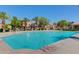 Community pool with palm trees, lounge chairs, water features, and residential buildings at 1367 S Country Club S Dr # 1125, Mesa, AZ 85210
