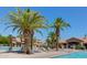 Community pool surrounded by palm trees and lounge chairs, with residential buildings in the background at 1367 S Country Club S Dr # 1125, Mesa, AZ 85210