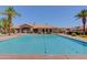 Community pool with palm trees, lounge chairs, water features, and a clubhouse in the background at 1367 S Country Club S Dr # 1125, Mesa, AZ 85210