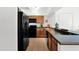 Functional kitchen featuring dark appliances and countertops, paired with wood cabinetry for a modern look at 15095 N Thompson Peak Pkwy # 3032, Scottsdale, AZ 85260