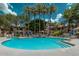A community pool is surrounded by palm trees, lounge chairs, and patio furniture at 15095 N Thompson Peak Pkwy # 3032, Scottsdale, AZ 85260