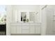 Bright bathroom featuring double sinks, white cabinetry, and a shower with a curtain at 15600 W Williams St, Goodyear, AZ 85338