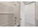 This bathroom features a shower and tub combination and a white tile surround at 15600 W Williams St, Goodyear, AZ 85338