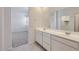 Bathroom with double sink vanity, large mirror, and a view into the bedroom at 15600 W Williams St, Goodyear, AZ 85338