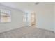 Cozy bedroom with plush carpet, two windows, and en suite bathroom access at 15600 W Williams St, Goodyear, AZ 85338