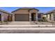 Charming single-story home featuring a paved driveway, neutral stucco, and a covered entryway at 15600 W Williams St, Goodyear, AZ 85338