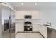 Modern kitchen with white cabinets, quartz countertops, and stainless steel appliances at 15600 W Williams St, Goodyear, AZ 85338