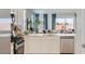 Beautiful kitchen and view of the living area, featuring stainless steel appliances and white cabinetry at 15627 W Williams St, Goodyear, AZ 85338